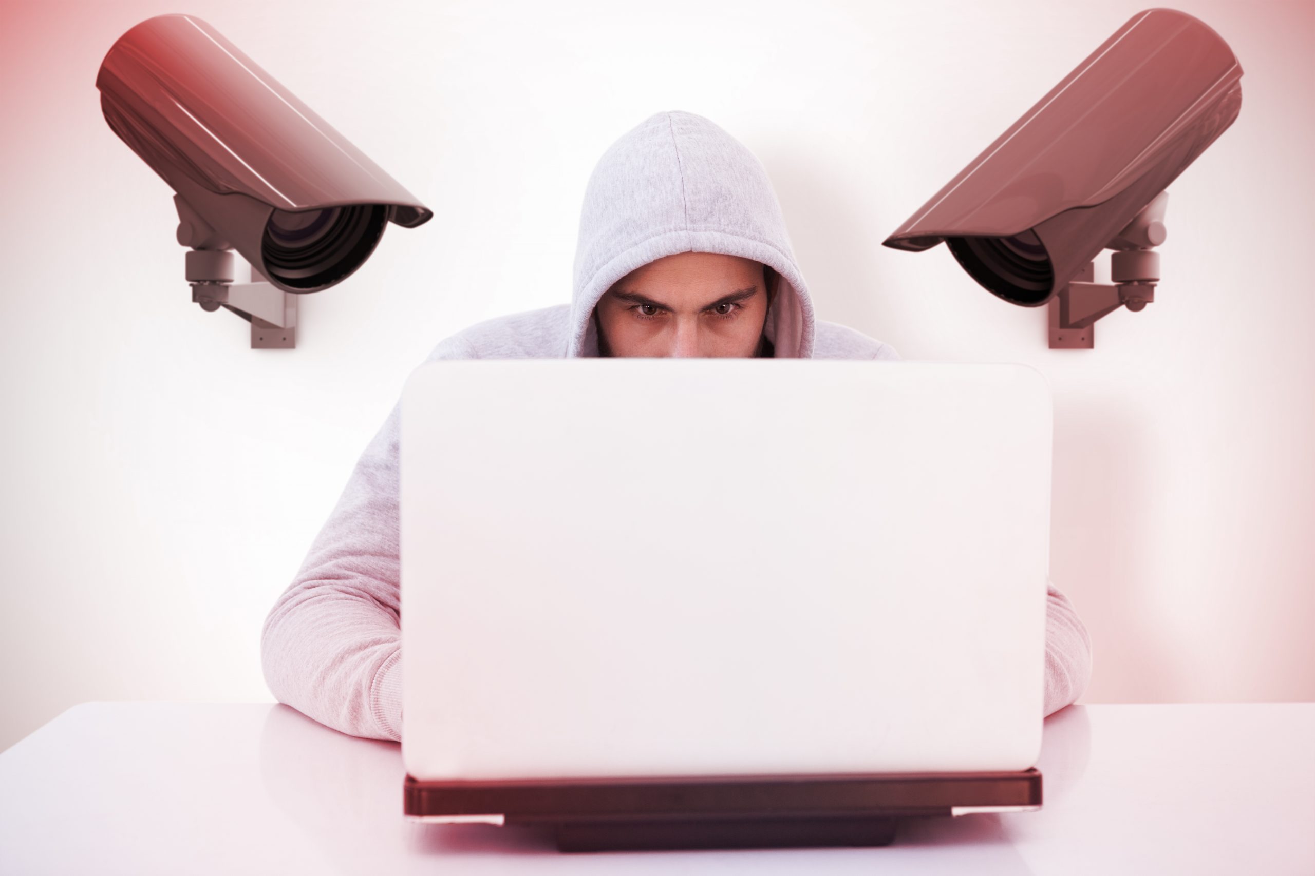 Serious burglar hacking into laptop against cctv camera